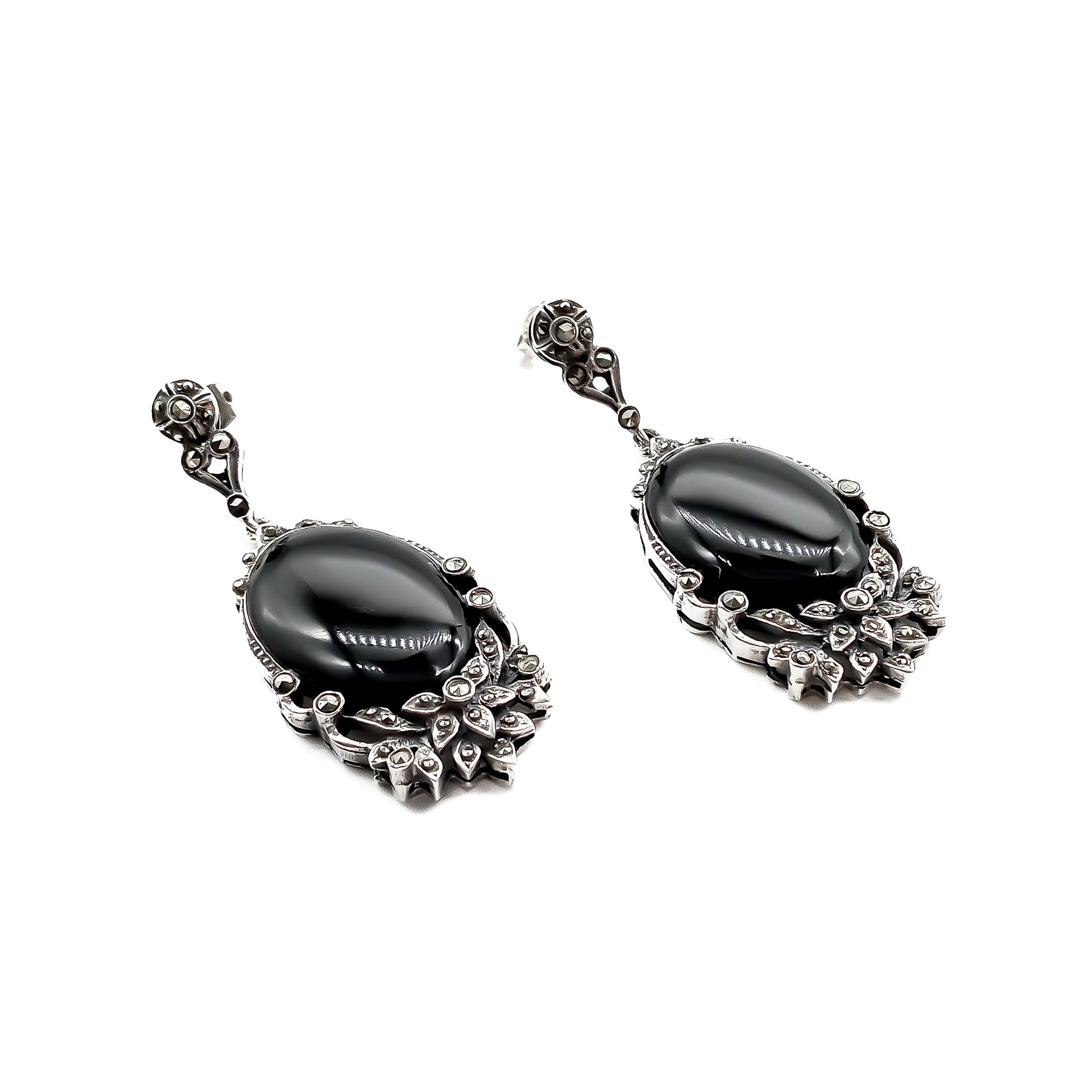 Stunning vintage silver drop earrings, each set with an oval onyx cabochon stone and marcasites in a floral design.