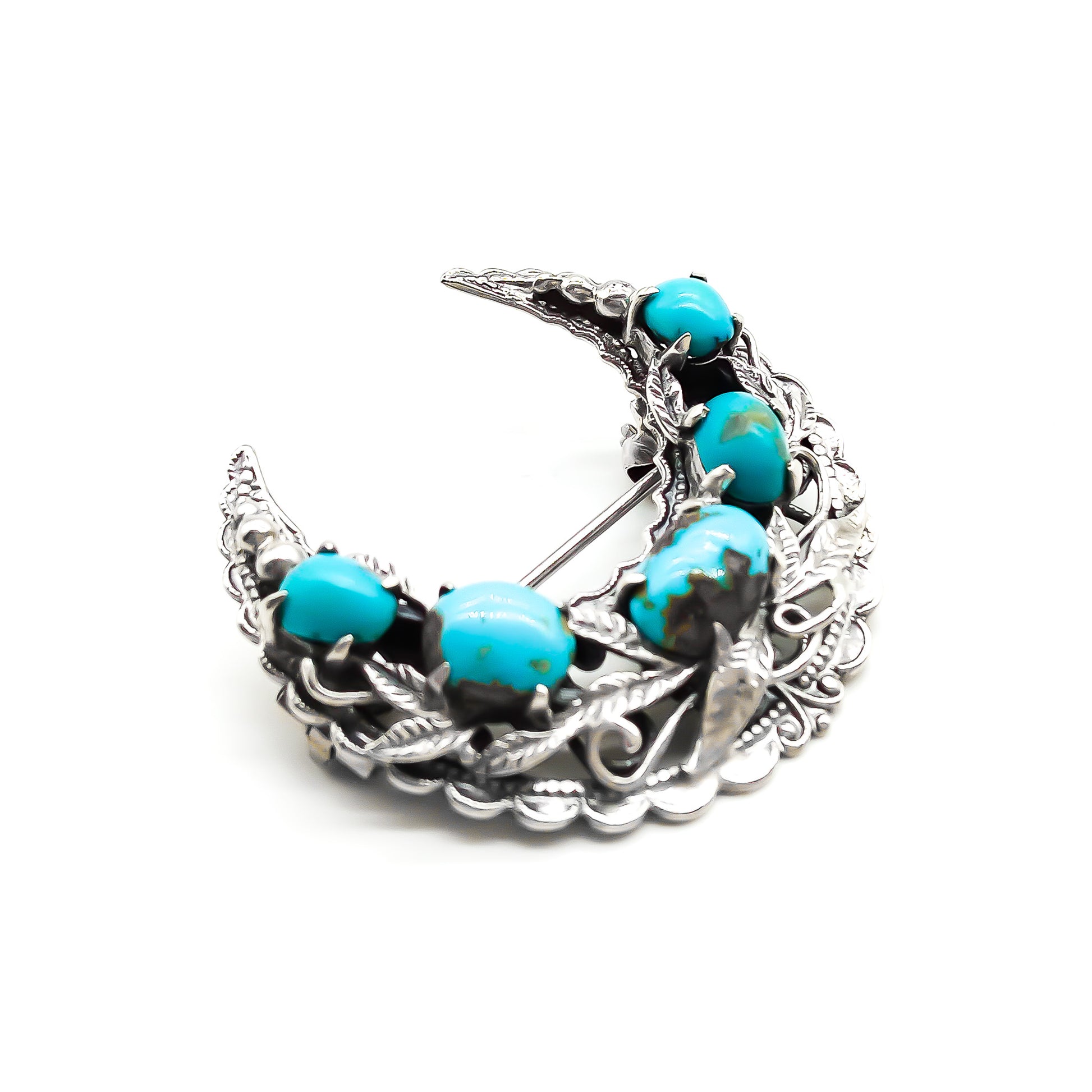 Ornate silver crescent brooch set with five oval turquoise stones. Circa 1930’s