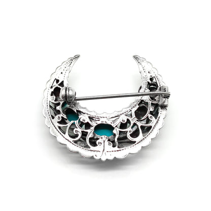Ornate silver crescent brooch set with five oval turquoise stones. Circa 1930’s