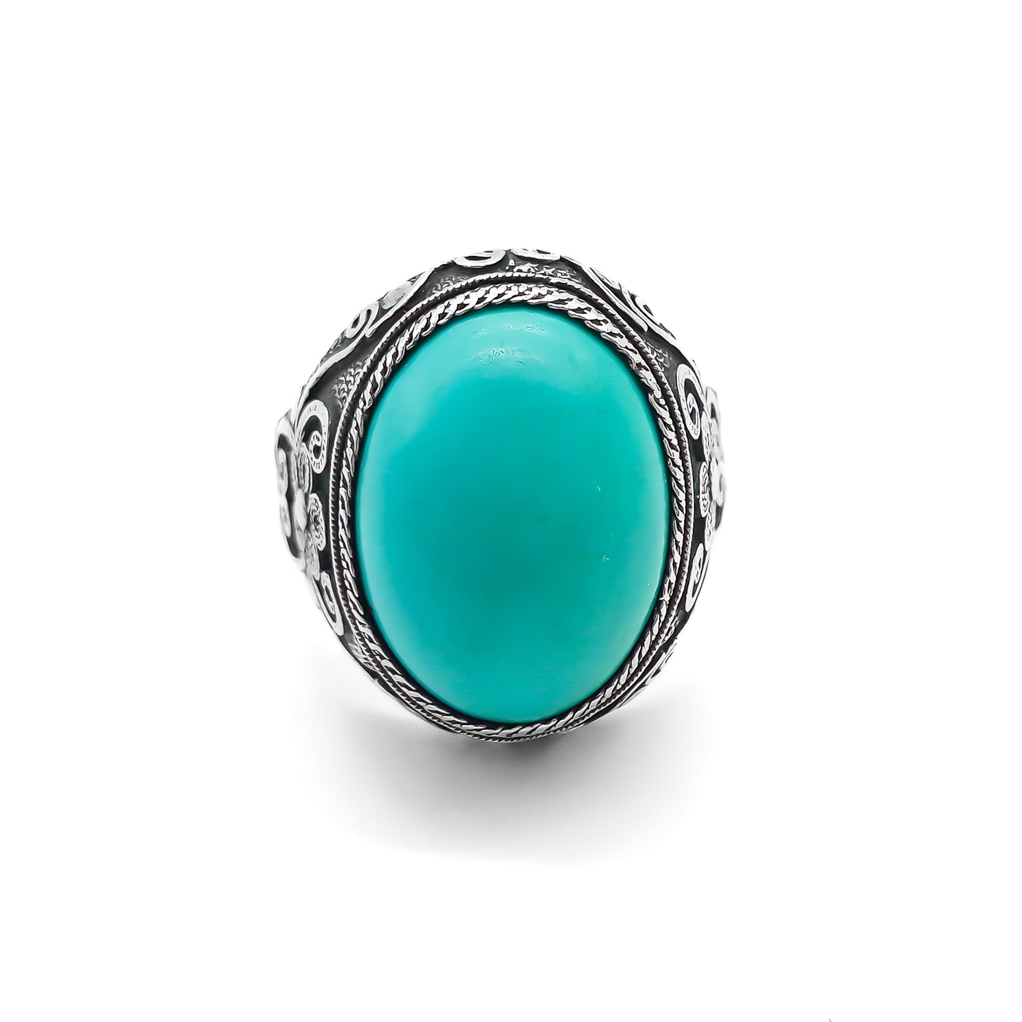 Silver ring set with a beautiful cabochon turquoise stone and ornate filigree embellishment.
