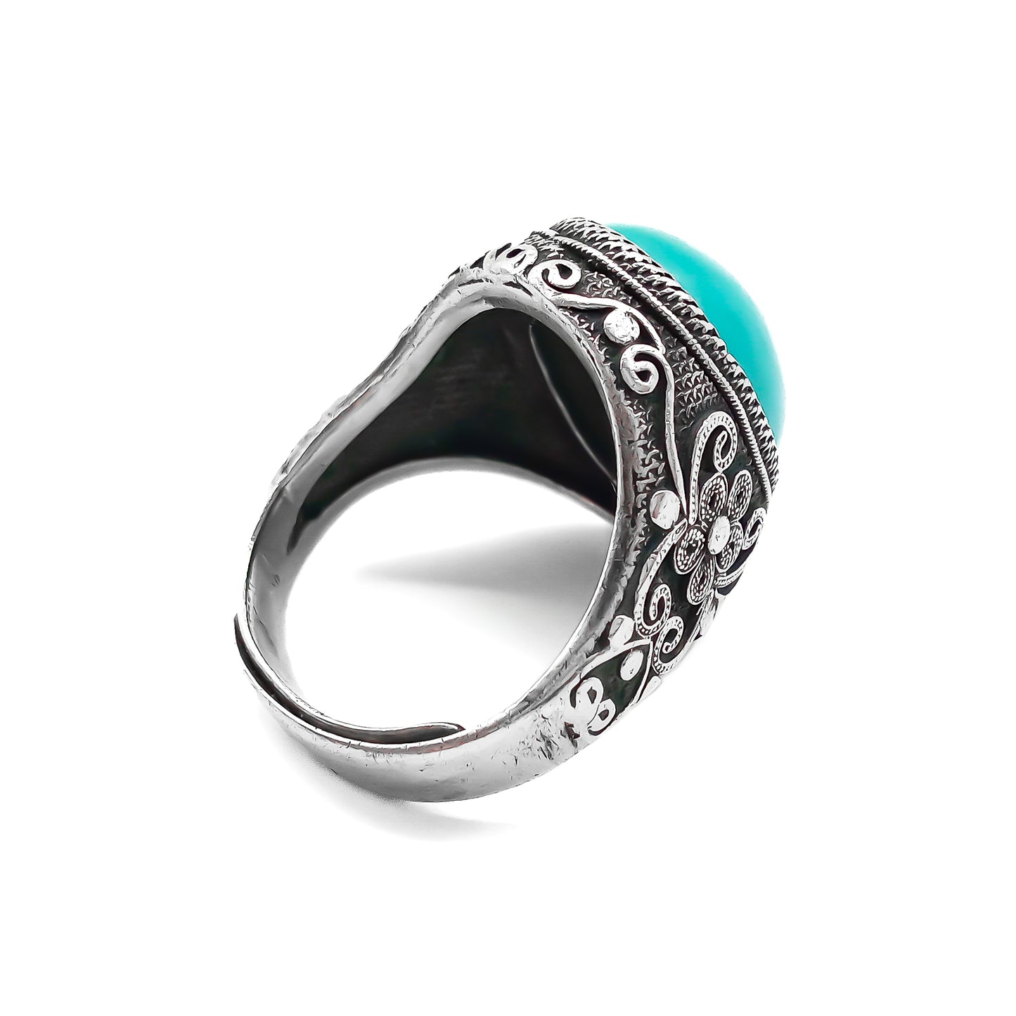 Silver ring set with a beautiful cabochon turquoise stone and ornate filigree embellishment.