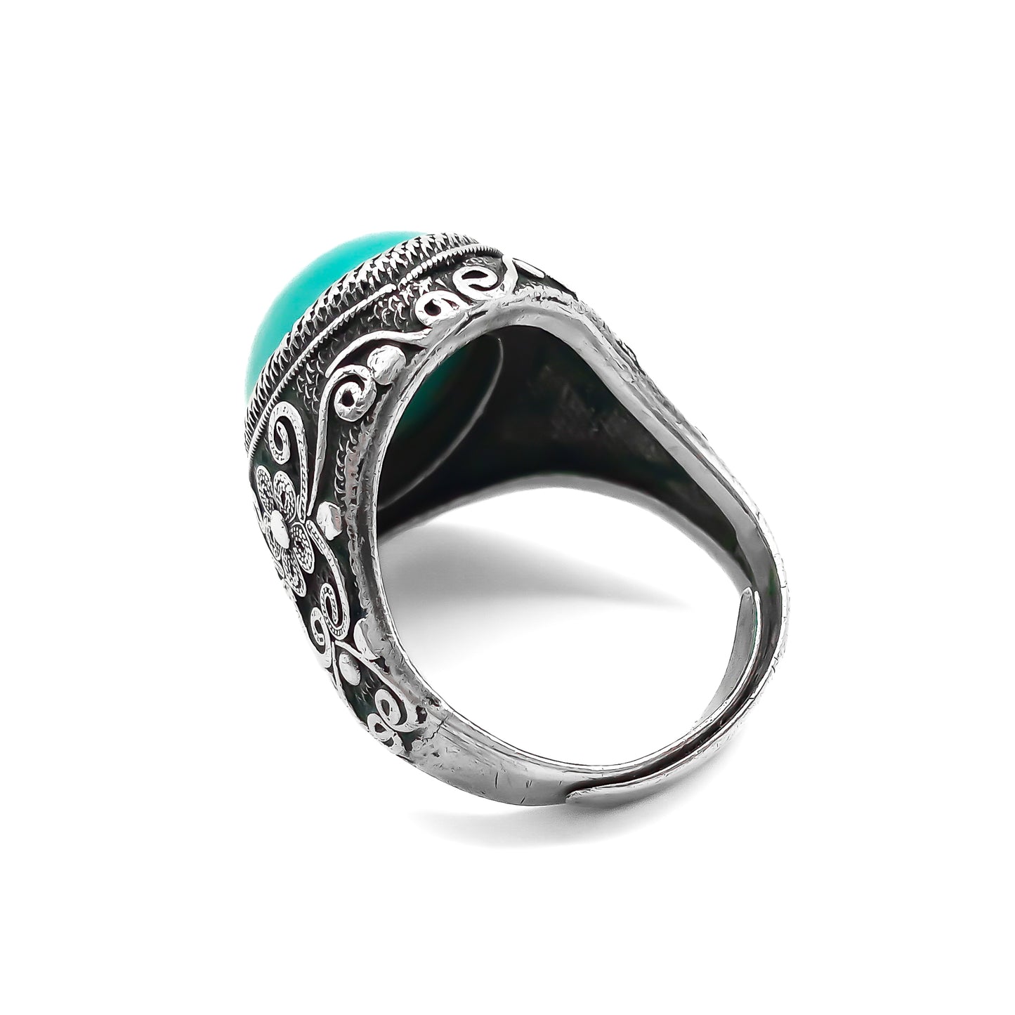 Silver ring set with a beautiful cabochon turquoise stone and ornate filigree embellishment.
