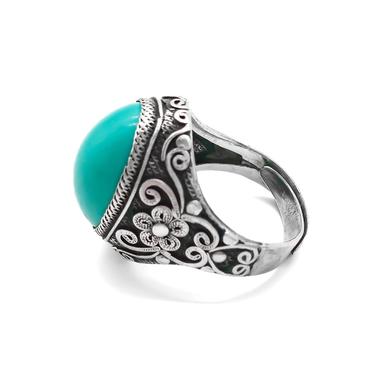 Silver ring set with a beautiful cabochon turquoise stone and ornate filigree embellishment.
