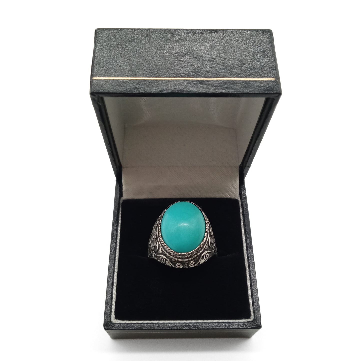 Silver ring set with a beautiful cabochon turquoise stone and ornate filigree embellishment.