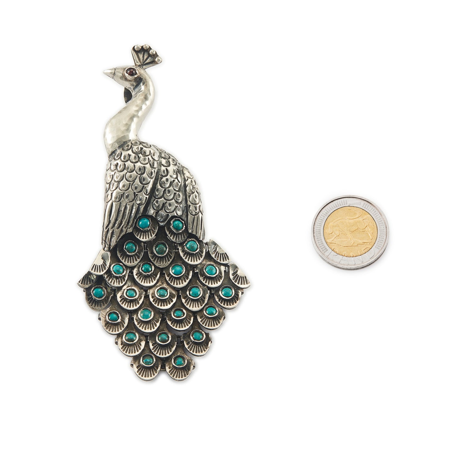 Magnificent Mexican oxidised high grade silver peacock pendant/brooch with twenty-three cabochon turquoise stones set in its articulated tail feathers, with a garnet eye.