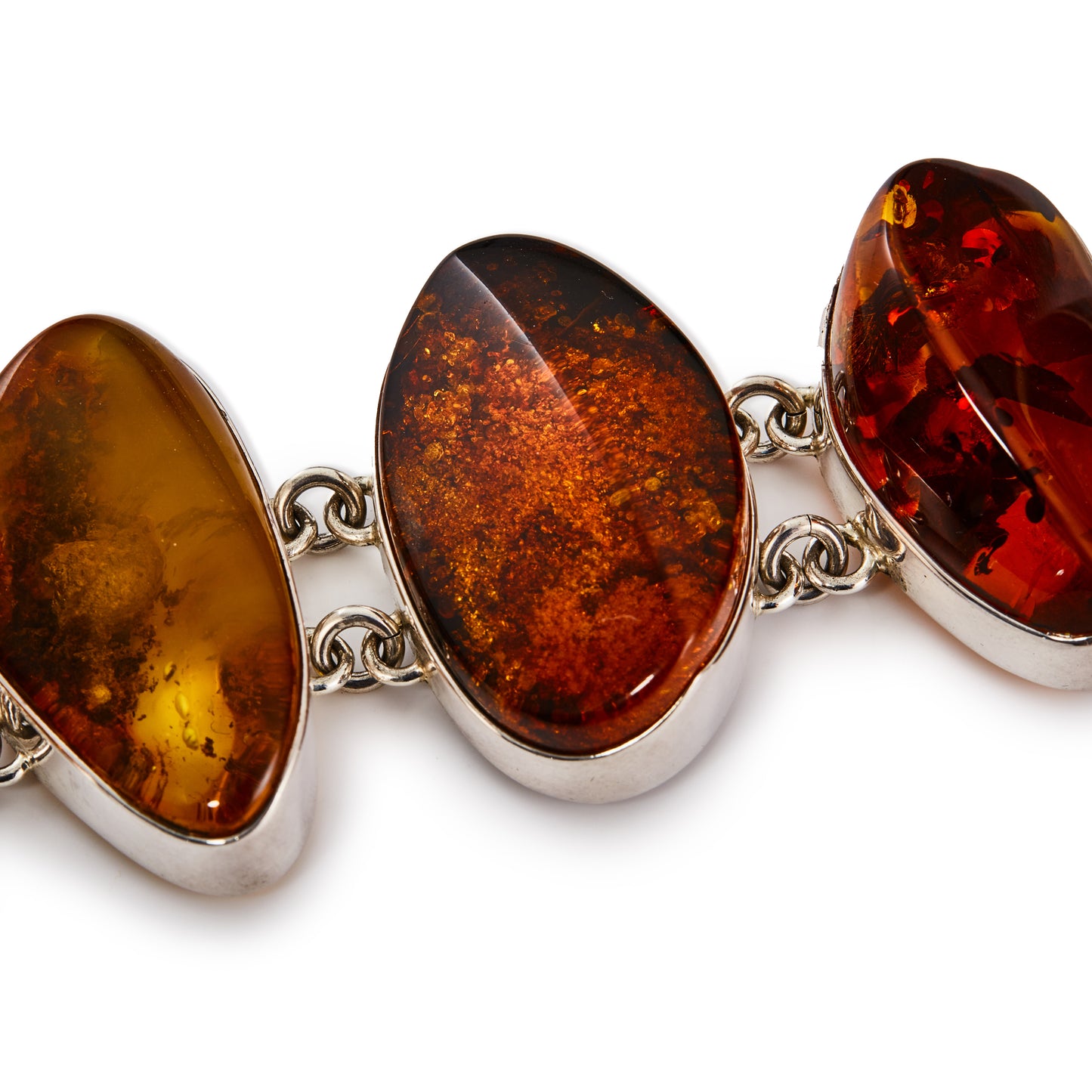 Stunning sterling silver belcher link bracelet, set with six beautiful organic shaped natural pieces of amber in a variety of different hues. Safety chain attached.