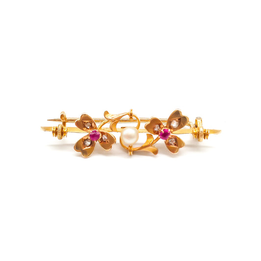 Dainty 15ct gold Victorian bar brooch set with two rubies, six small diamonds and a pearl in a clover leaf setting.
