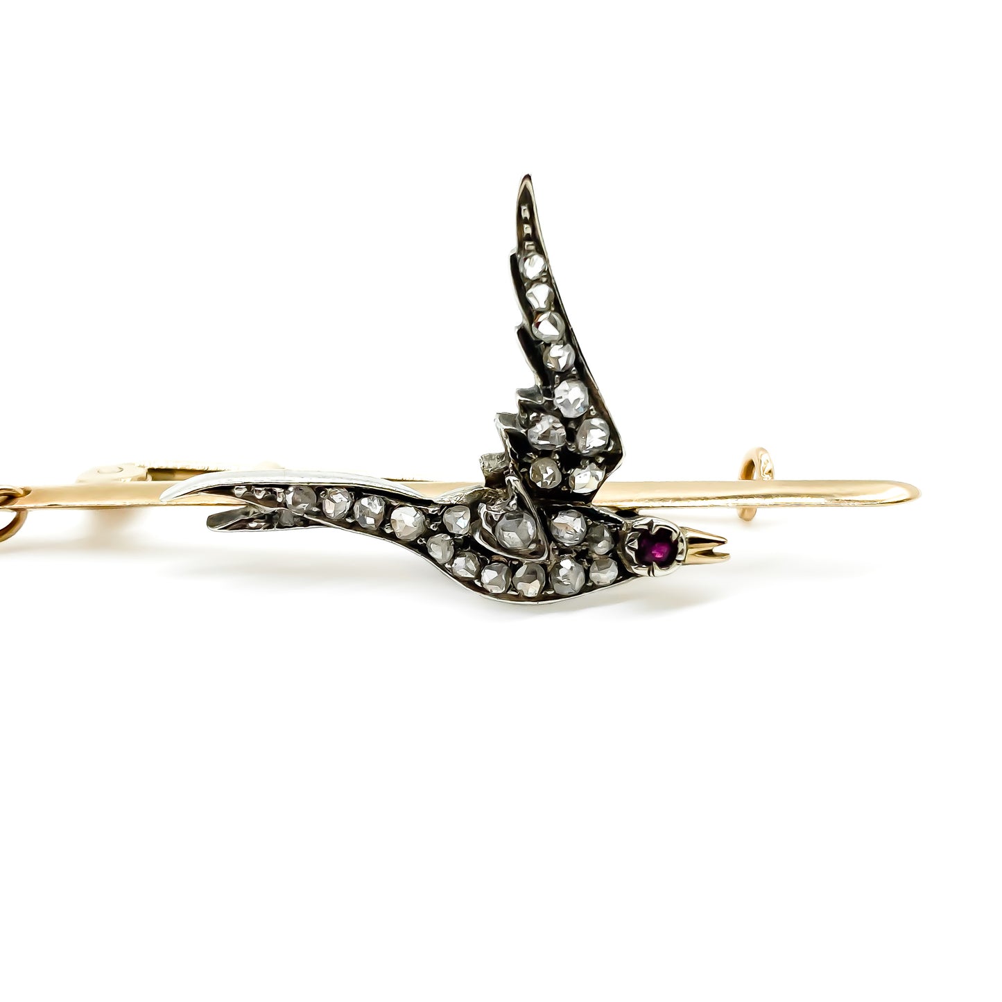 Exquisite Victorian 15ct rose gold bar brooch depicting a bird, set with twenty-three mine cut diamonds and a ruby eye. Gold safety chain attached.