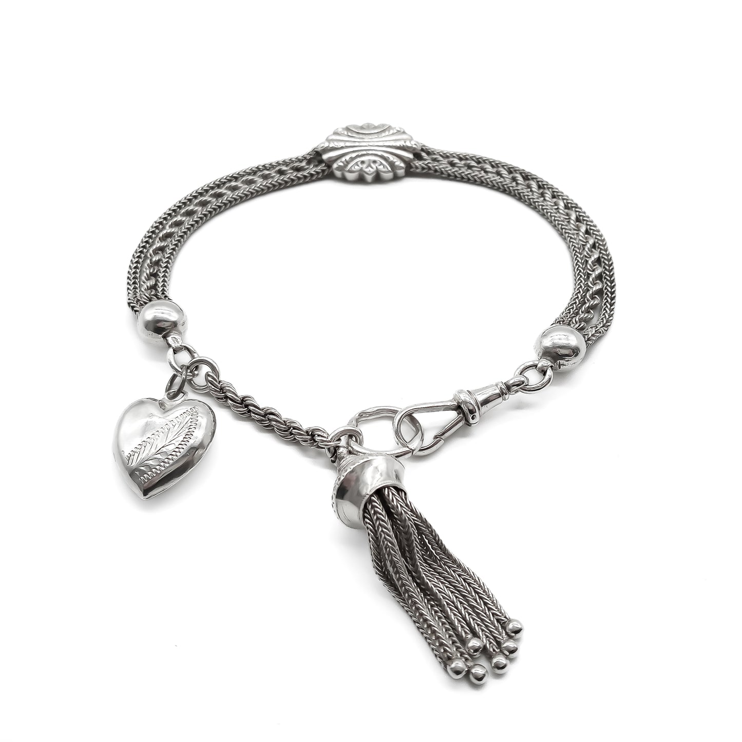 Victorian silver albertina bracelet with ornate detail, a dog clip, a tassel and a heart charm.