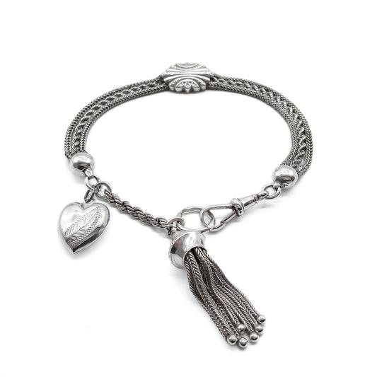 Victorian silver albertina bracelet with ornate detail, a dog clip, a tassel and a heart charm. 