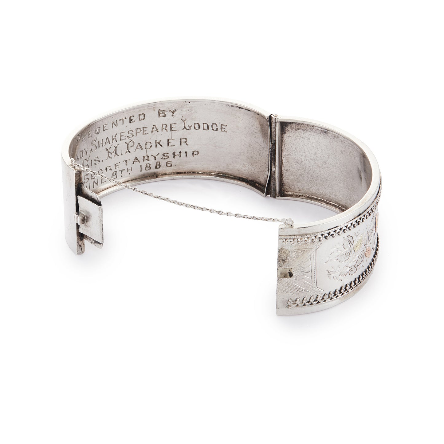 Beautiful Victorian silver and gold bangle embossed with a floral design and Etruscan detail around the rim. Safety chain attached.