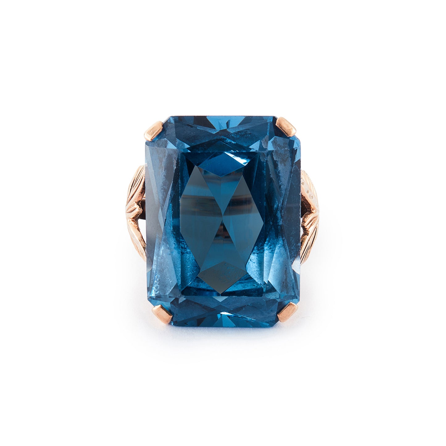 Beautifully faceted deep-blue lab-grown spinel in a lovely 9ct rose gold ring setting with a leaf design.
