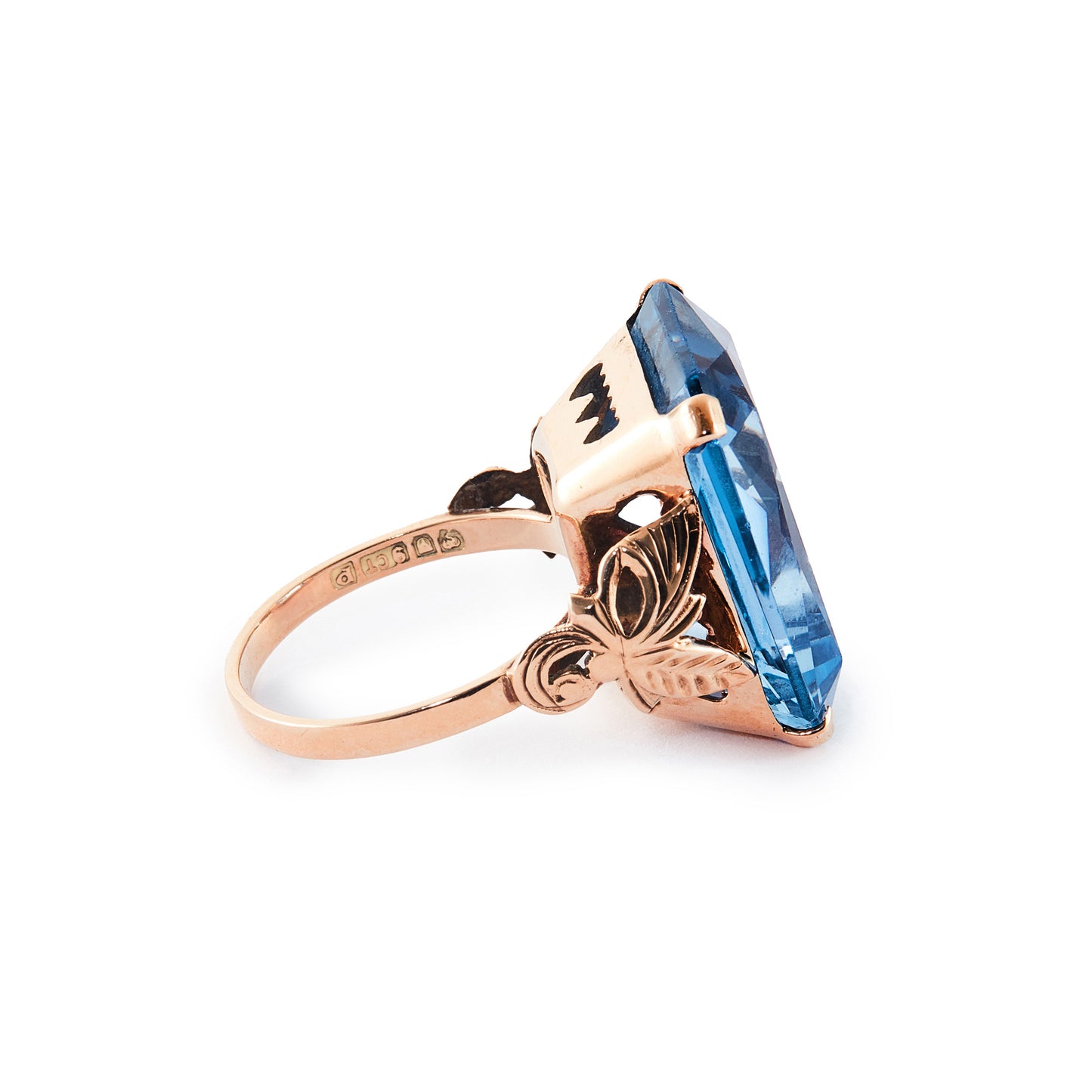 Beautifully faceted deep-blue lab-grown spinel in a lovely 9ct rose gold ring setting with a leaf design.