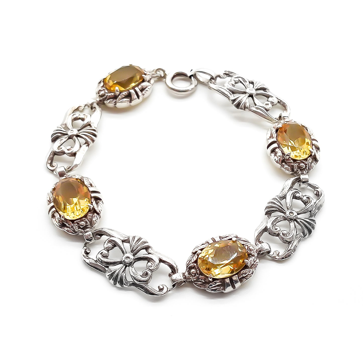Stunning ornate sterling silver bracelet set with four beautifully faceted oval citrines.