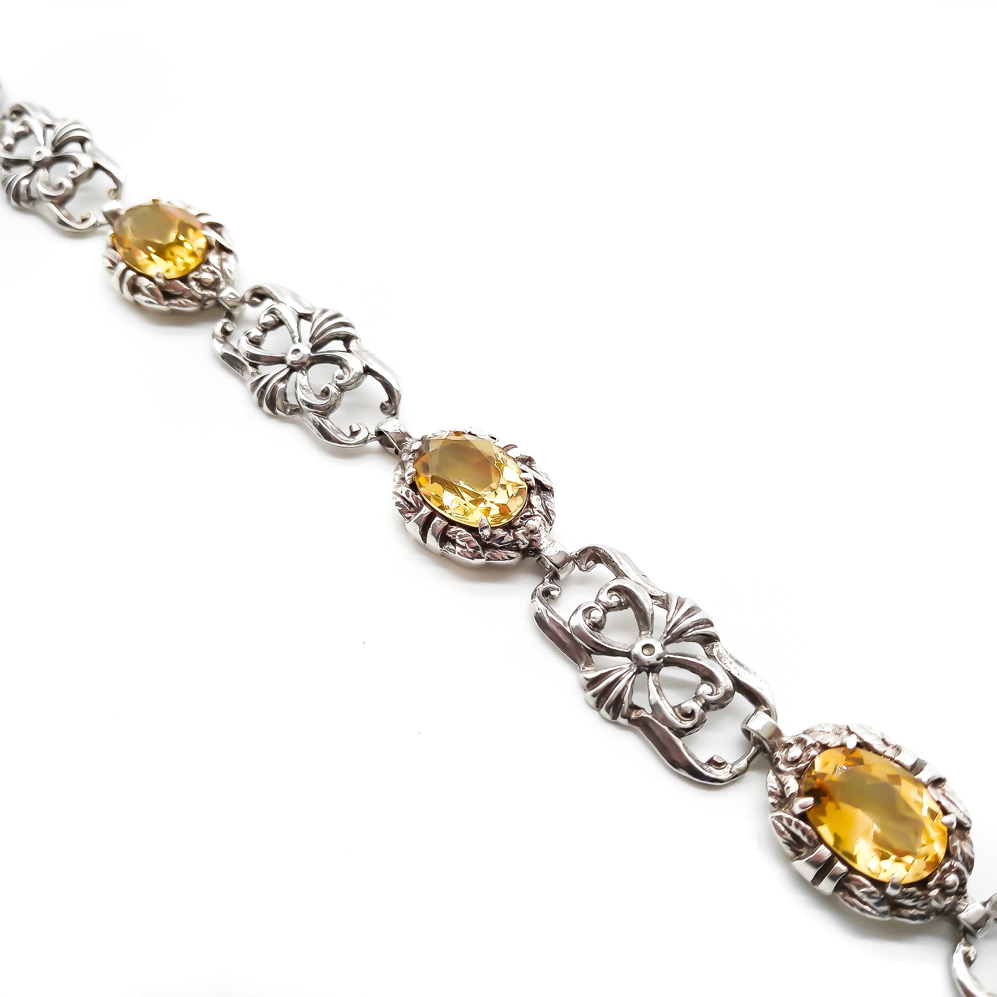 Stunning ornate sterling silver bracelet set with four beautifully faceted oval citrines.
