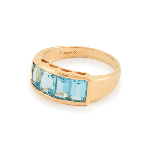 Classic 14ct yellow gold ring with four faceted, bright blue topaz stones in a channel setting.