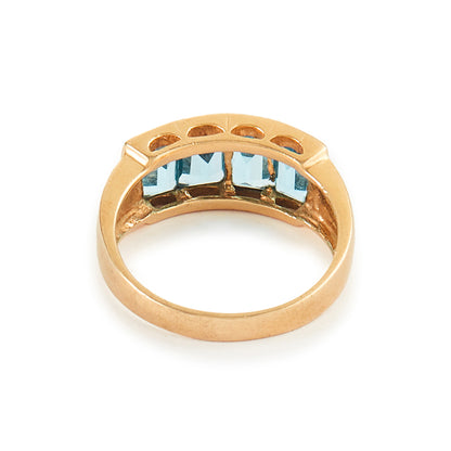Classic 14ct yellow gold ring with four faceted, bright blue topaz stones in a channel setting.