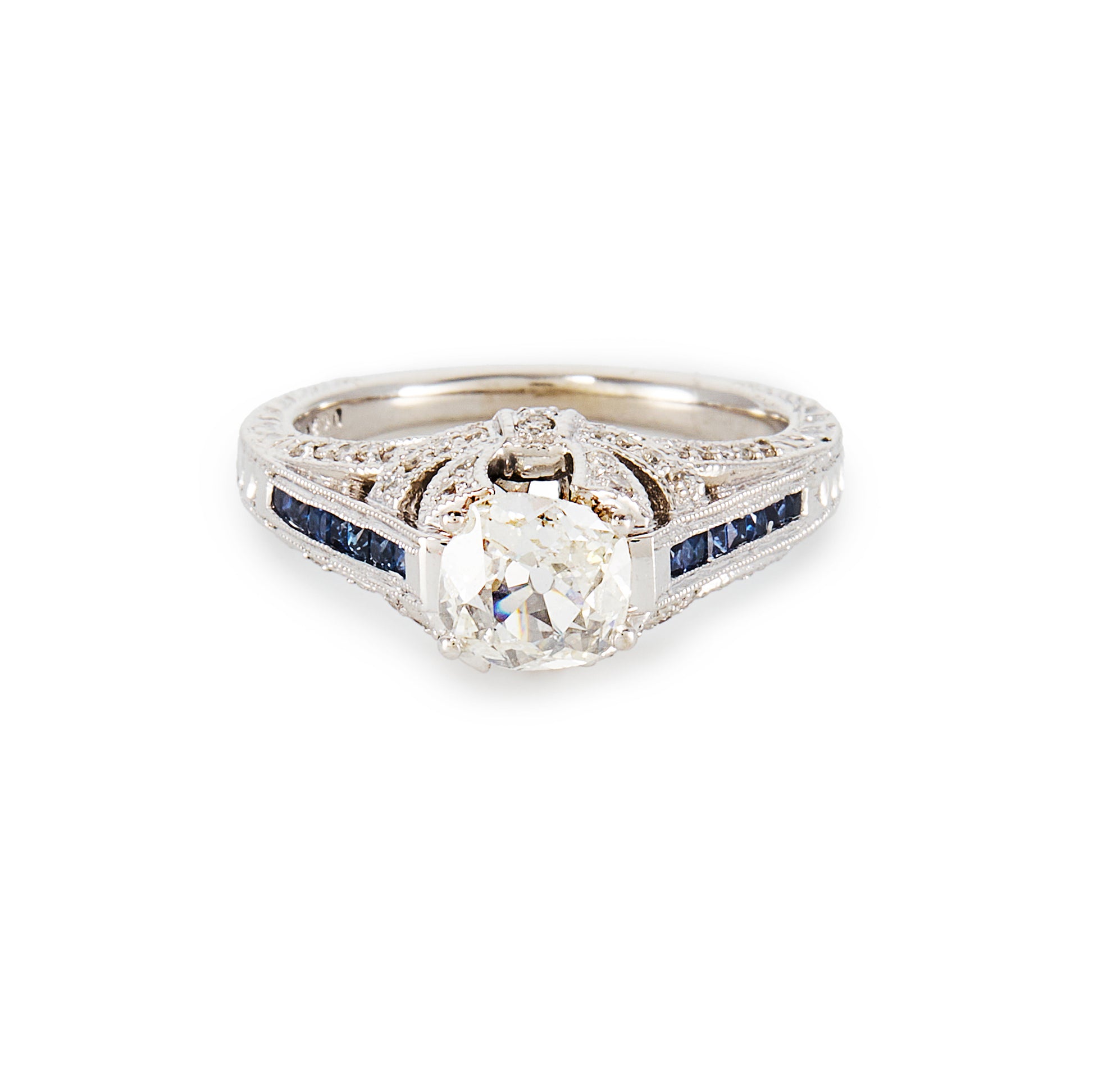 Magnificent 14ct white gold ring, set with a 0.70ct Old-European-Cut diamond, as well as seven princess-cut sapphires on each shoulder. The ring also features a diamond encrusted gallery. A valuation from The Gem Lab is included.