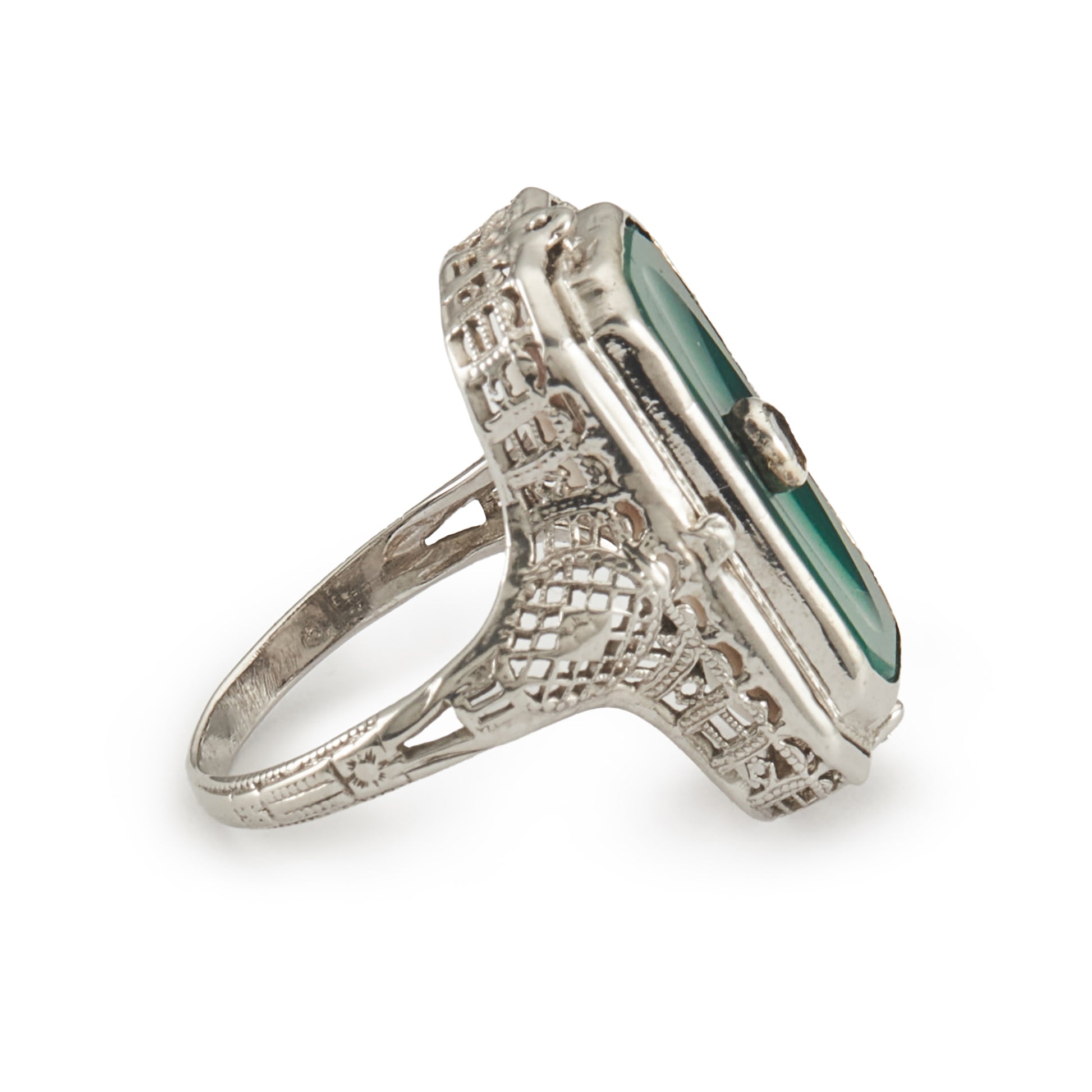 A very unusual 14ct white gold swivel ring set with a cameo of a woman wearing a diamond necklace on one side, and a green chrysoprase disc centred by a diamond on the other side. The versatile centre piece is surrounded by intricate filigree detail.