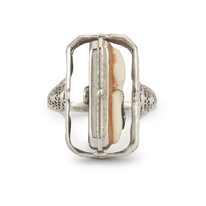A very unusual 14ct white gold swivel ring set with a cameo of a woman wearing a diamond necklace on one side, and a green chrysoprase disc centred by a diamond on the other side. The versatile centre piece is surrounded by intricate filigree detail.