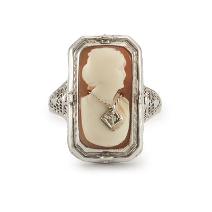 A very unusual 14ct white gold swivel ring set with a cameo of a woman wearing a diamond necklace on one side, and a green chrysoprase disc centred by a diamond on the other side. The versatile centre piece is surrounded by intricate filigree detail.