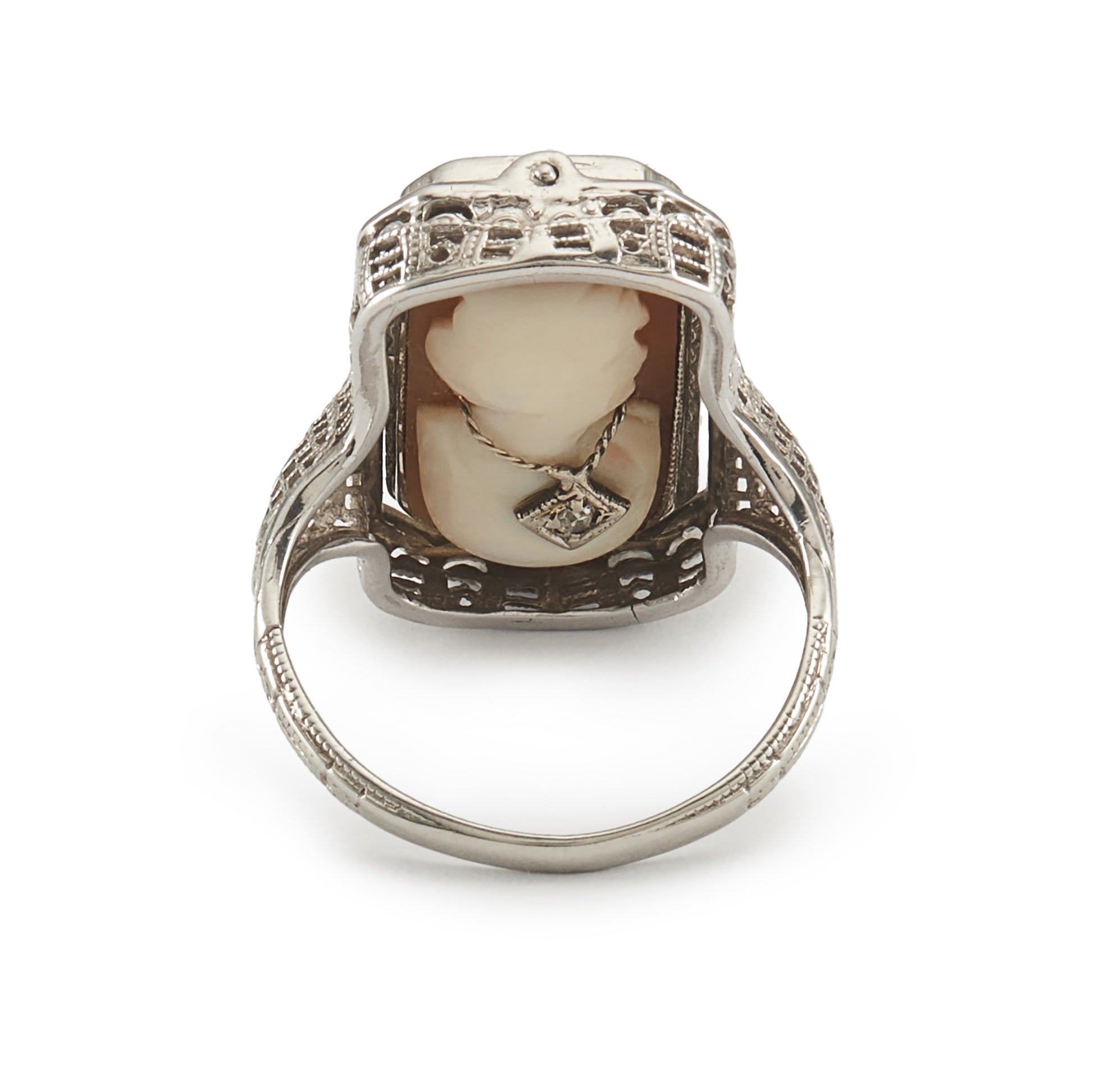 A very unusual 14ct white gold swivel ring set with a cameo of a woman wearing a diamond necklace on one side, and a green chrysoprase disc centred by a diamond on the other side. The versatile centre piece is surrounded by intricate filigree detail.