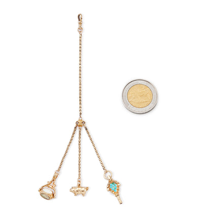 Highly sought after Victorian 15ct yellow gold attachment consisting of a dog clip, and three exquisite miniature pieces hanging from individual chains. The attachment consists of: a beautifully carved 15ct gold turquoise watch key, a 9ct gold pig charm and a 15ct gold swivel fob set with citrine, green agate and white chalcedony. Can be worn as a pendant or attached onto an Albertina.
