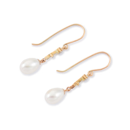 Delicate vintage 18ct gold dangling earrings, each set with a mine cut diamond and a lustrous pearl drop.