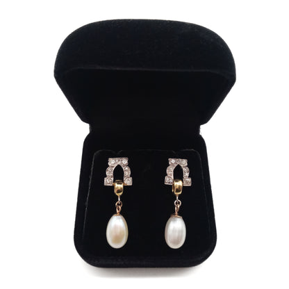 Stunning pair of 18ct white and yellow gold dangling earrings, each set with six small diamonds and a pearl drop.