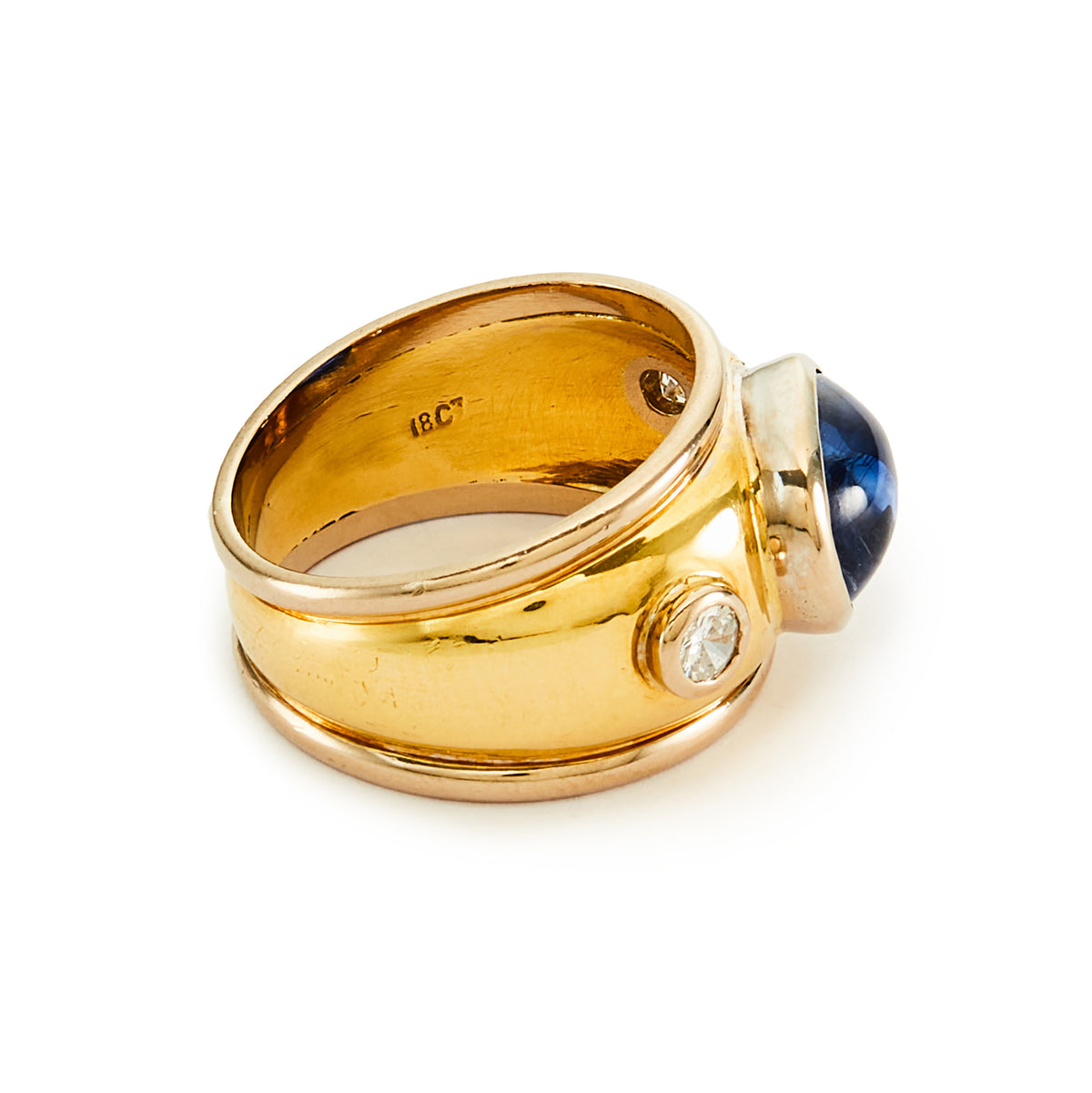 Glamorous 18ct yellow and white gold ring tube-set with a centre cabochon sapphire and a diamond on each side.