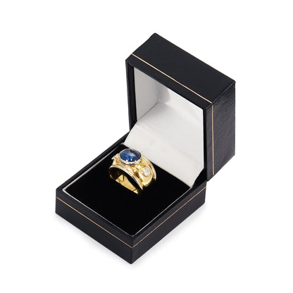 Glamorous 18ct yellow and white gold ring tube-set with a centre cabochon sapphire and a diamond on each side.
