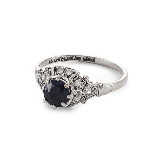 Classic Art Deco 18ct white gold and platinum ring set with a centre 0.70ct dark blue sapphire, surrounded by ten small diamonds.