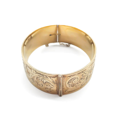 Beautifully engraved 9ct yellow gold bangle with a bronze core. Safety chain attached. Circa 1940’s