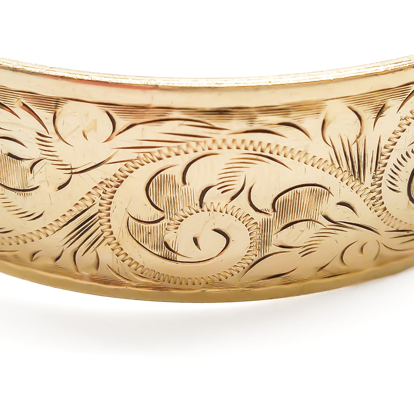 Beautifully engraved 9ct yellow gold bangle with a bronze core. Safety chain attached. Circa 1940’s