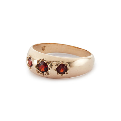 Classic 9ct gold gypsy ring set with three faceted garnets, each in a star setting.
London 1976.