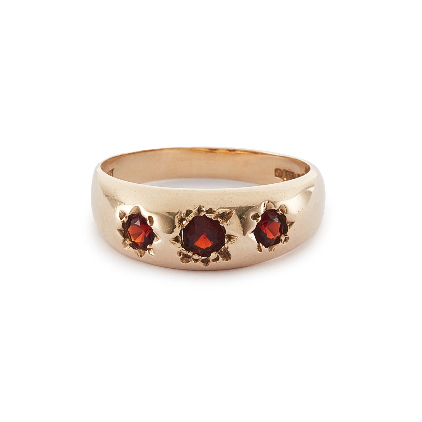 Classic 9ct gold gypsy ring set with three faceted garnets, each in a star setting.
London 1976.