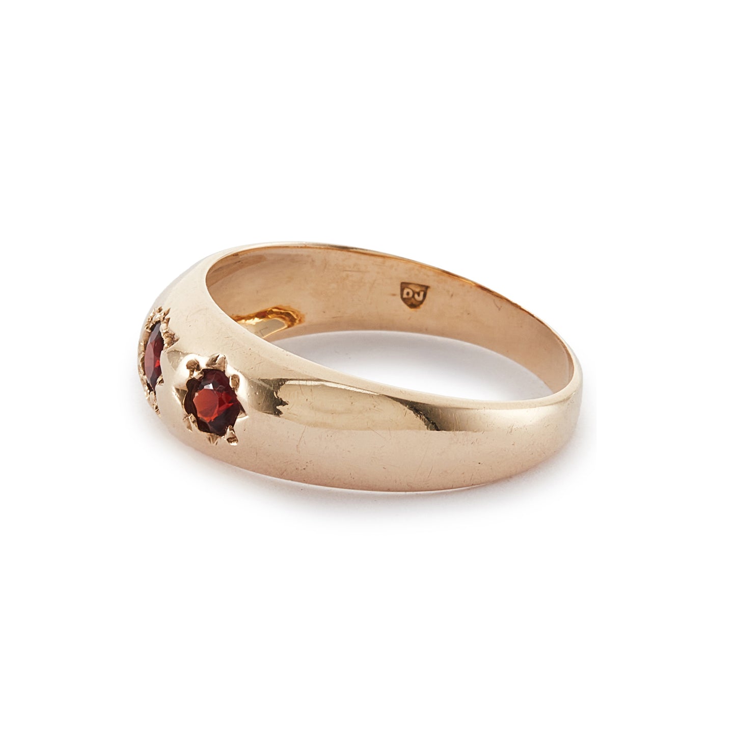 Classic 9ct gold gypsy ring set with three faceted garnets, each in a star setting.
London 1976.