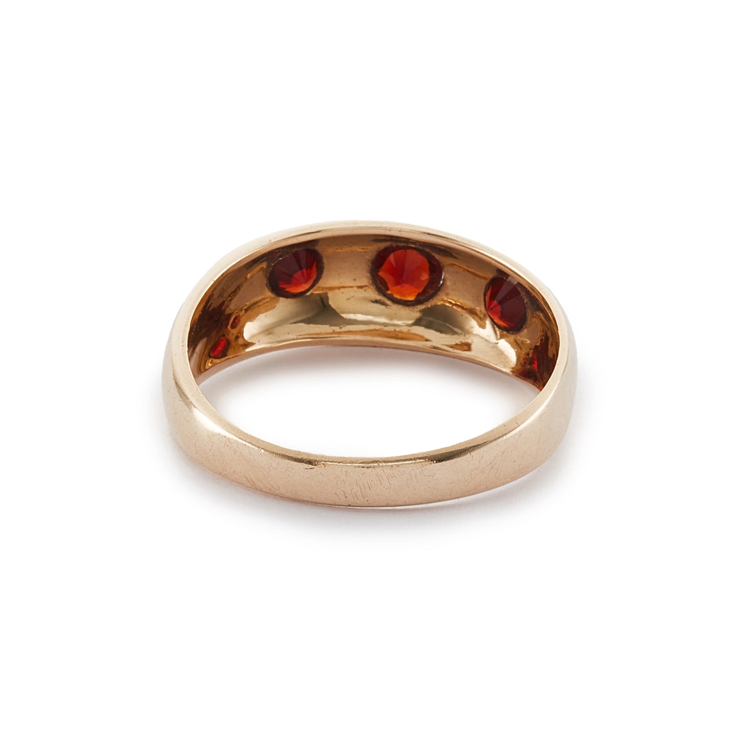 Classic 9ct gold gypsy ring set with three faceted garnets, each in a star setting.
London 1976.