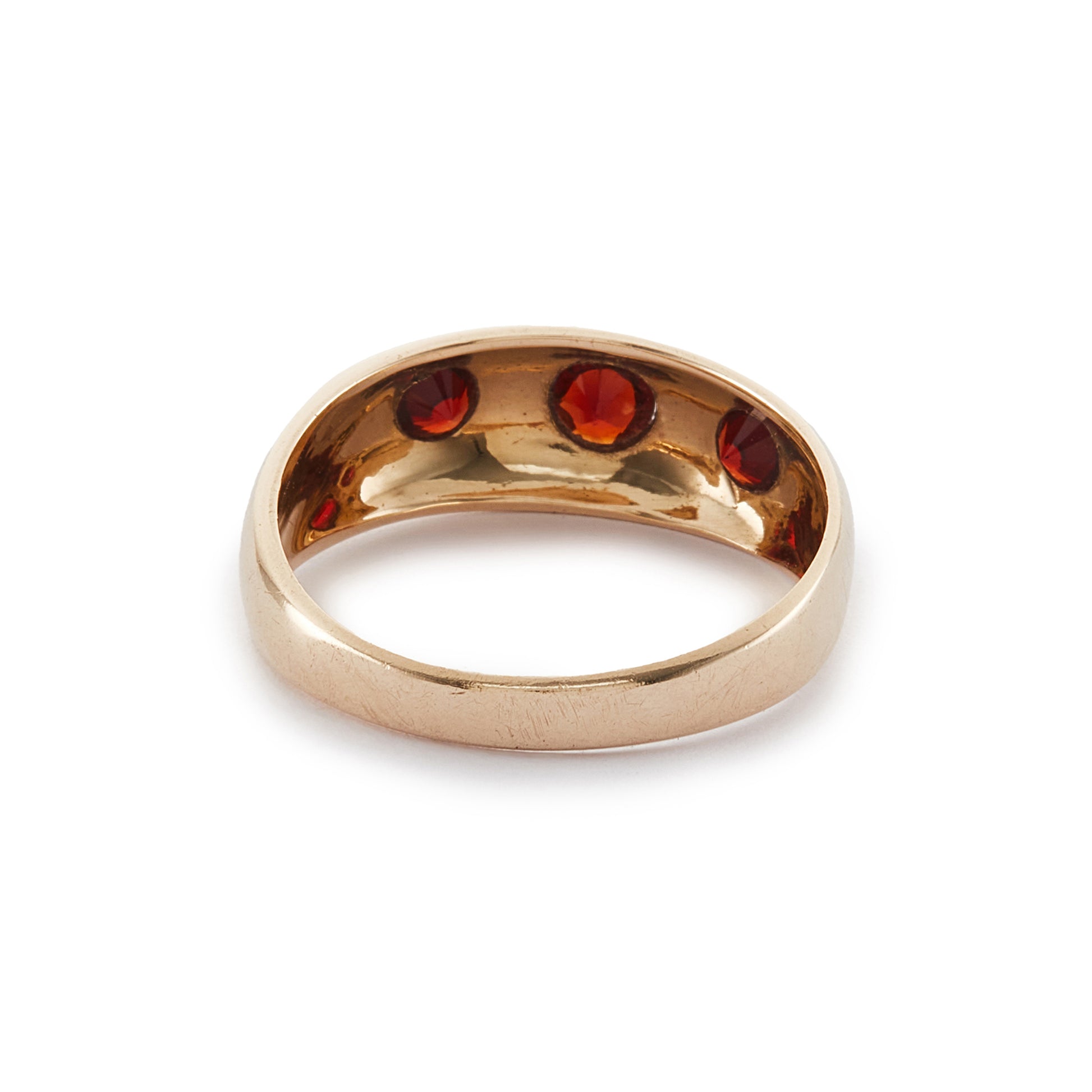 Classic 9ct gold gypsy ring set with three faceted garnets, each in a star setting.
London 1976.