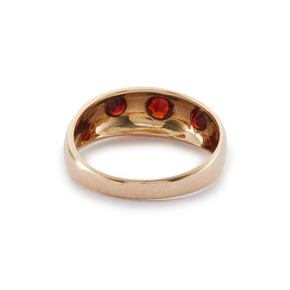 Classic 9ct gold gypsy ring set with three faceted garnets, each in a star setting.
London 1976.