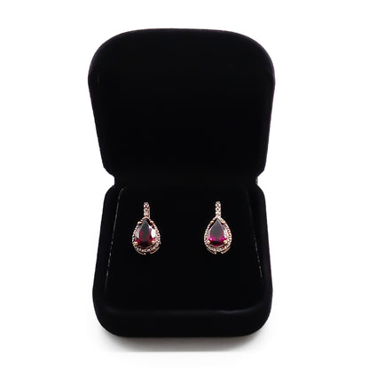 Classic 9ct gold stud earrings, each set with a deep red teardrop garnet in a diamond halo setting.