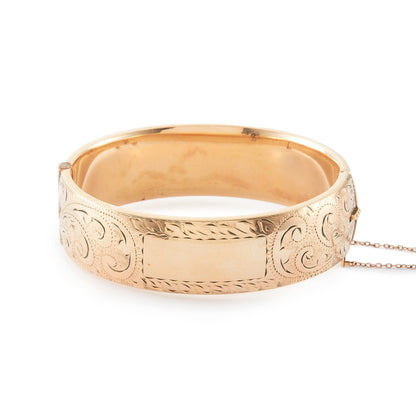 Vintage, beautifully engraved ⅕ 9ct rose gold metal core hinged bangle with a safety chain.