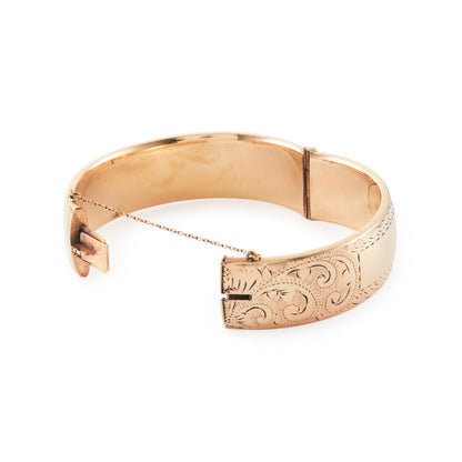 Vintage, beautifully engraved ⅕ 9ct rose gold metal core hinged bangle with a safety chain.