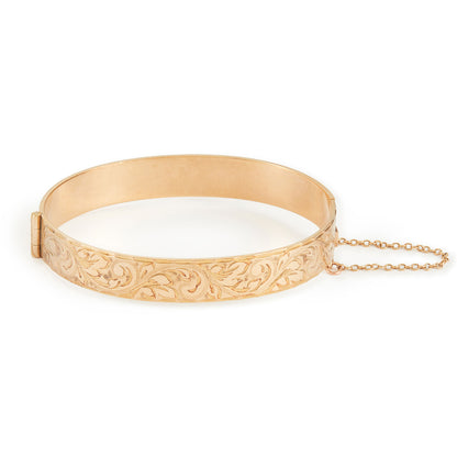 Beautifully engraved 9ct gold metal core bangle. Hinge clasp with safety chain attached.