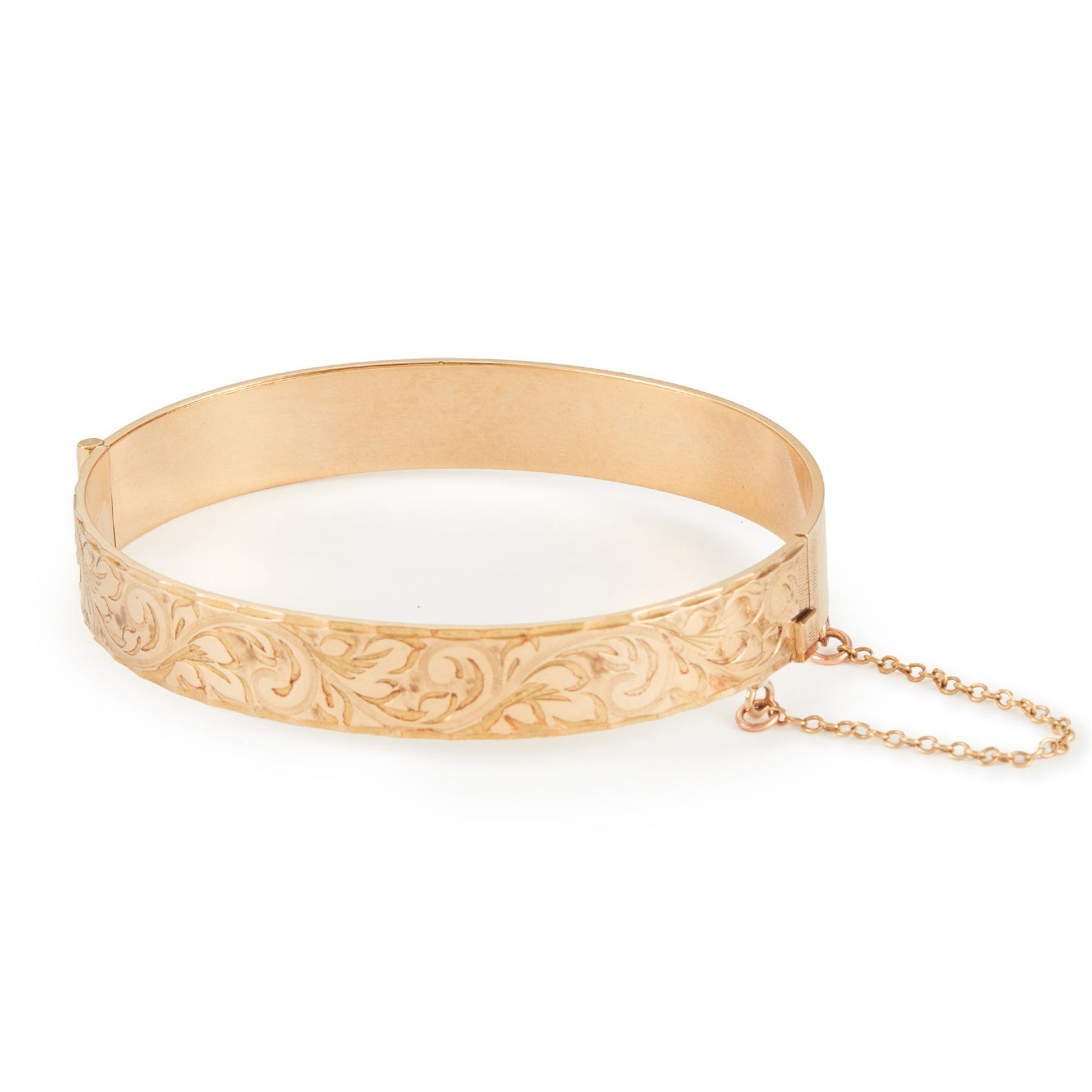 Beautifully engraved 9ct gold metal core bangle. Hinge clasp with safety chain attached.