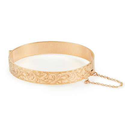 Beautifully engraved 9ct gold metal core bangle. Hinge clasp with safety chain attached.