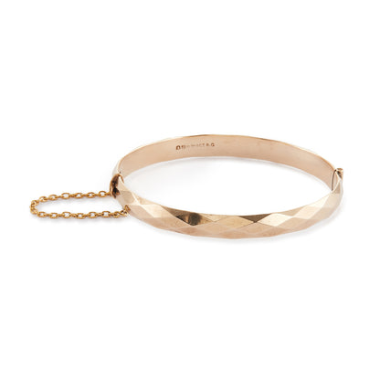 Classic 9ct rose gold (⅕) rolled gold bangle with harlequin design. Safety chain attached.