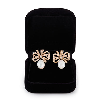 Lovely 9ct rose gold bow shaped earrings, each set with a small diamond and a lustrous pearl drop.