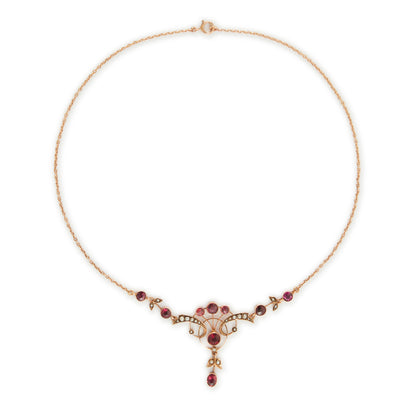 Exquisite Edwardian 9ct rose gold necklace set with nine rhodolite garnets and eighteen seed pearls.