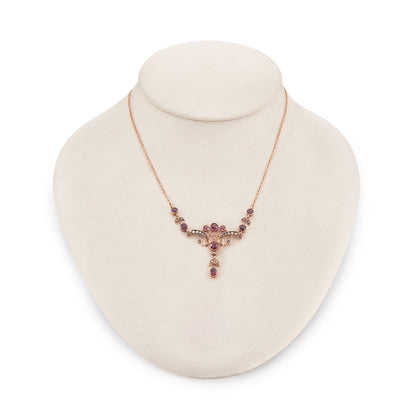 Exquisite Edwardian 9ct rose gold necklace set with nine rhodolite garnets and eighteen seed pearls.